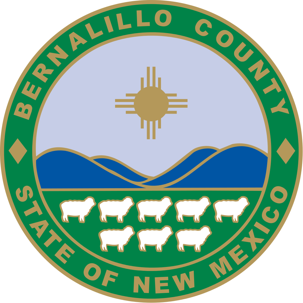 Bernalillo County Seal blue mountains golden sun sheep green and gold circular outline