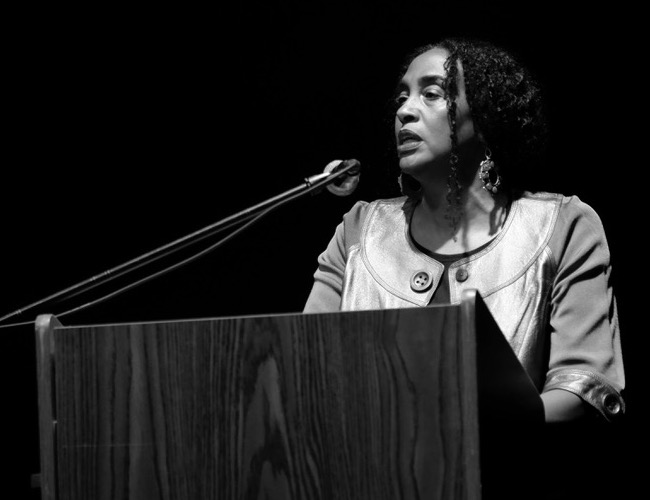 Black and white photo of AfroMundo Founder and Director Loida Maritza Perez at a podium